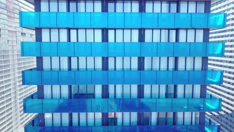 shot of reflections of sun, clouds and sky on glass windows of city skyscraper.