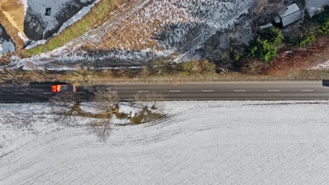 Wintry-landscape-from-above-with-driving-vehicles-at-a-road-as-parting-line