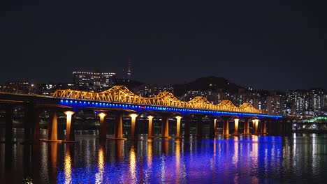 Noche-Iluminada-Del-Puente-Dongho-Con-Edificios-De-Gran-Altura-En-El-Fondo-Que-Se-Extienden-Sobre-El-Río-Han-Por-La-Noche-En-Seúl,-Corea-Del-Sur