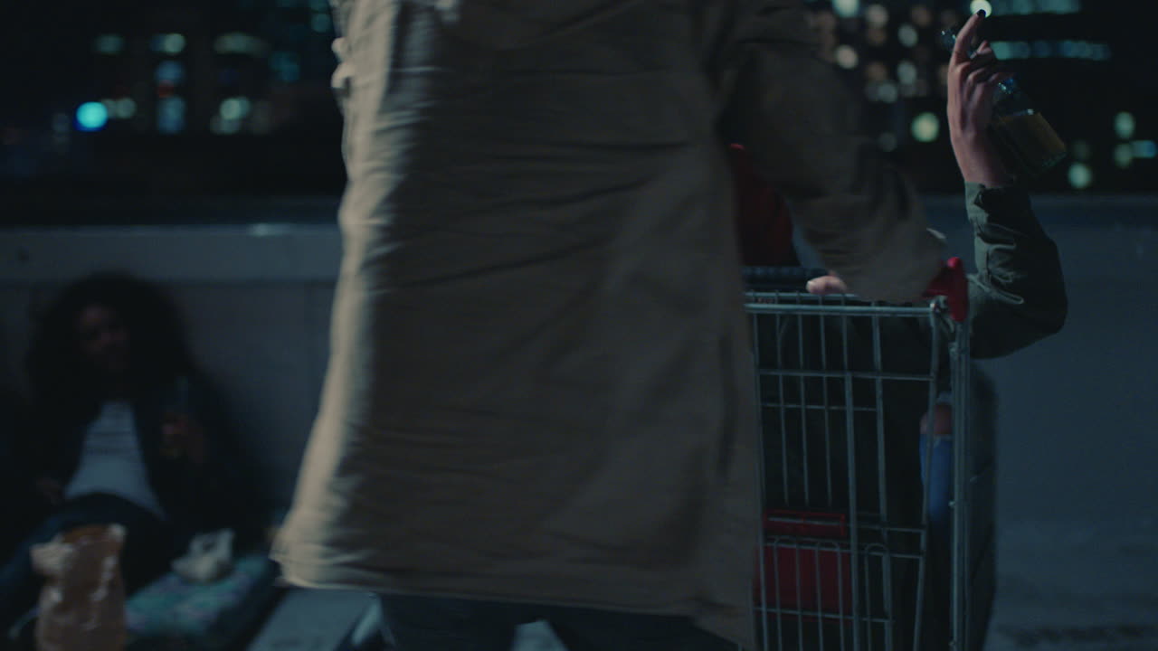 행복 한 친구 들 의 그룹 이 쇼핑 카트 를 가지고 놀고 밤 에 지붕 에서 즐겁게 주말 축하 파티 를 즐기고 있다