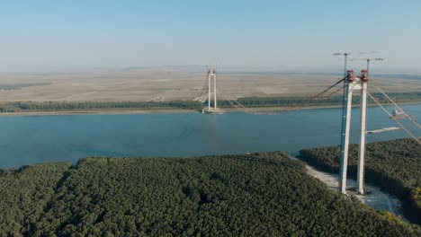 towers and main cables of braila bridge under construction over danube river in romania