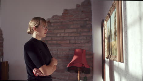 woman viewing a painting in a cozy living room