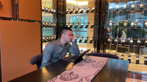 wealthy asian millennial man stressed while working on laptop inside luxurious home