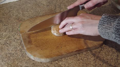 cortar un champiñón en una tabla de cortar de madera