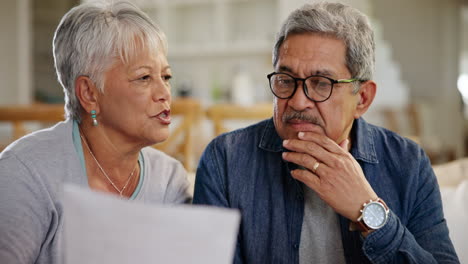 old couple, reading paperwork for bills