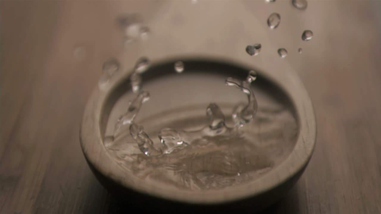 Drop in super slow motion falling in a wooden spoon