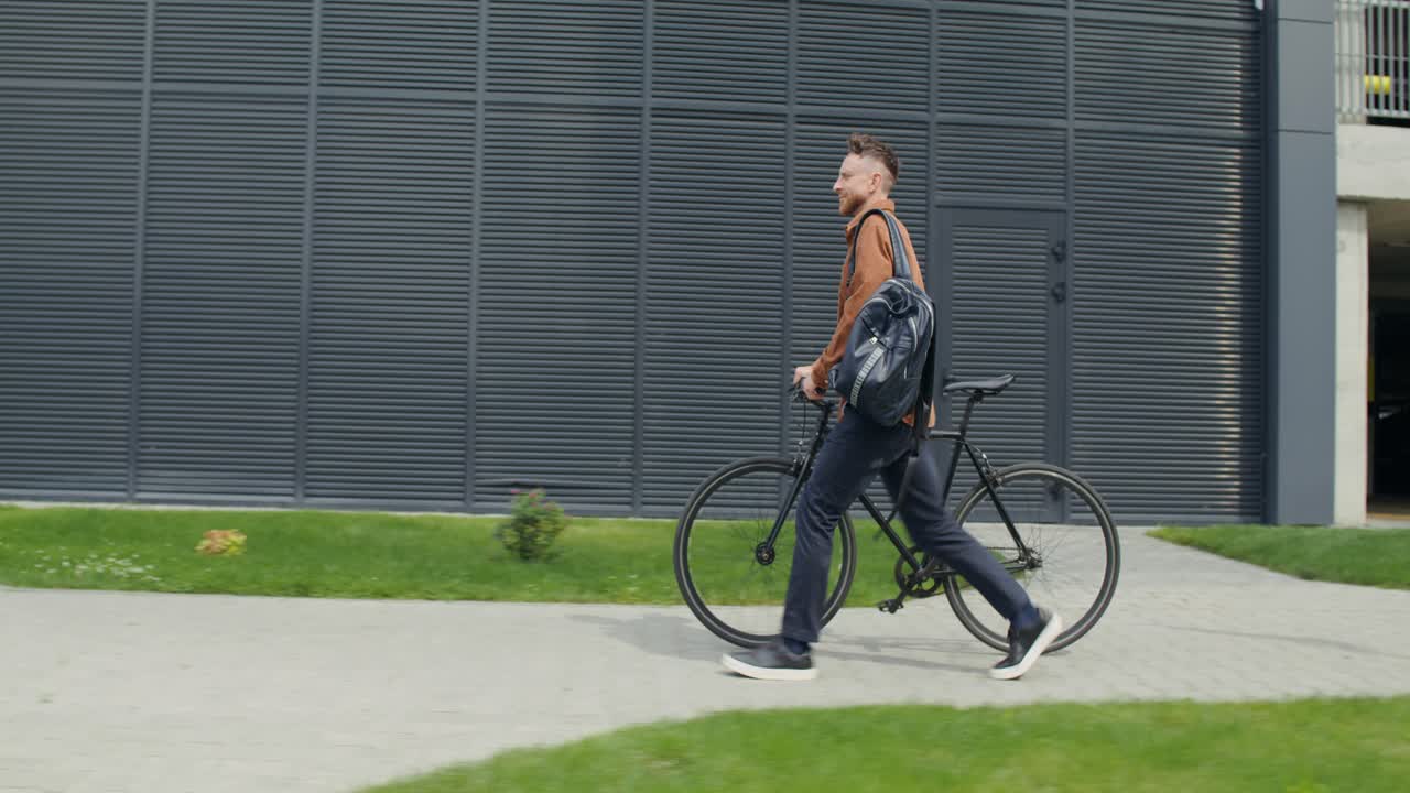En mann går med sykkelen sin i et urbant miljø
