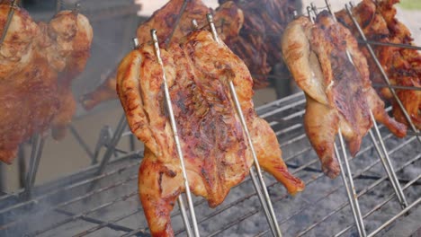 close-up of a chicken being grilled on a barbecue grill while smoke comes out