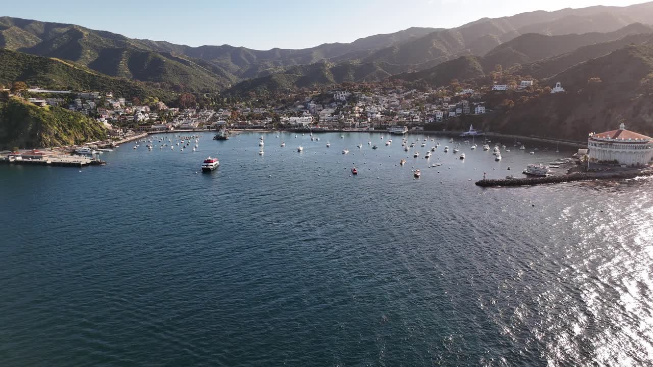 isla catalina, puerto de avalon con barcos y colinas circundantes a la luz del sol, vista aérea