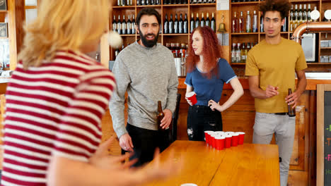 Friends-playing-beer-pong-on-table-in-bar-4k