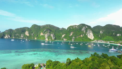 vista impresionante de la isla de phi phi en tailandia con barcos, yates y montañas en el fondo