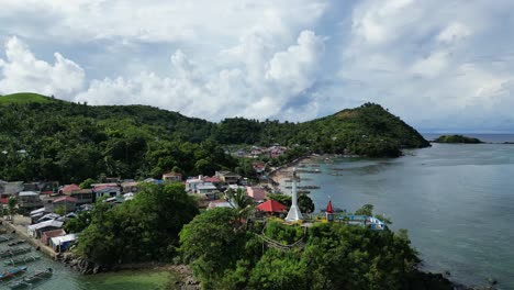 Tropical-fishing-town-surrounded-by-green-jungle,-aerial-orbit-establisher