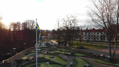 Imágenes-De-Una-Pequeña-Bandera-Sueca-Ondeando-Al-Viento-En-Un-Campo-De-Golf-En-Miniatura-En-Orgryte,-Gotemburgo,-Suecia