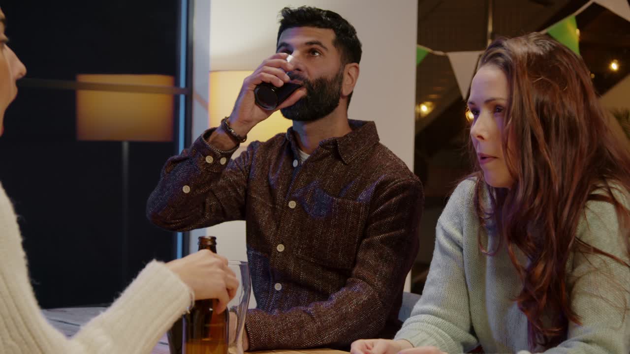 집에서 또는 술집에서 친구 그룹은 세인트 패트릭의 날 파티에서 축하하고 함께 술을 마시고 있습니다.