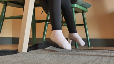 girl sitting on a chair with her feet dangling