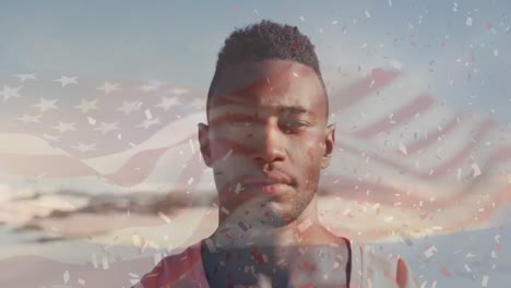 Animation-of-flag-of-united-states-of-america-and-confetti-over-african-american-man-on-beach