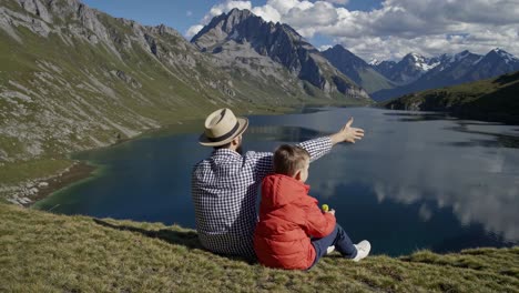 father and son enjoying a scenic mountain lake view