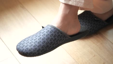 person wearing grey slippers