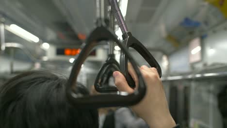 電車で手すりを持っている男