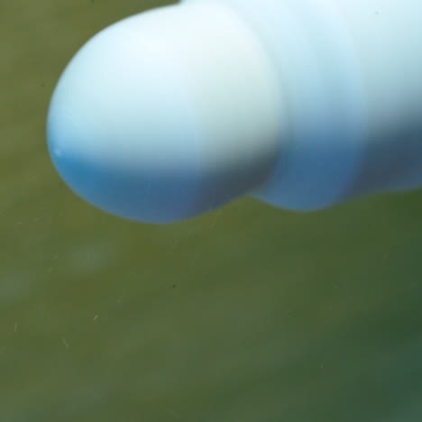 eye prosthesis is polishing by a special instrument. hands in gloves holding artificial plastic eye near the polishing machine. close-up.