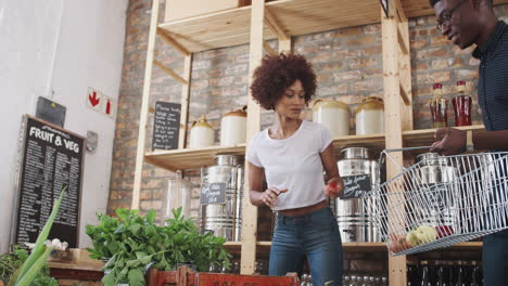 young couple buying fresh fruit and vegetables in sustainable plastic free grocery store