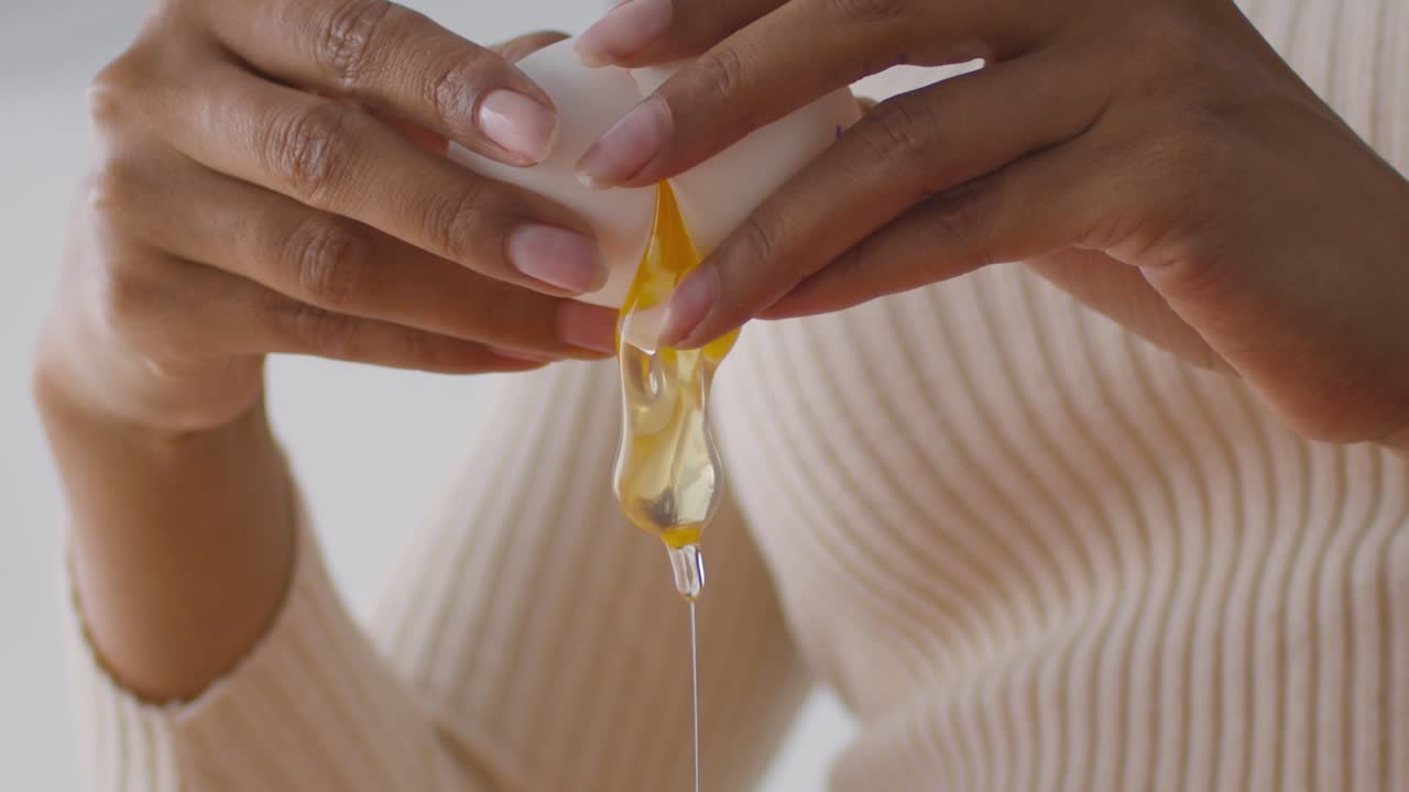 una mujer rompiendo un huevo.