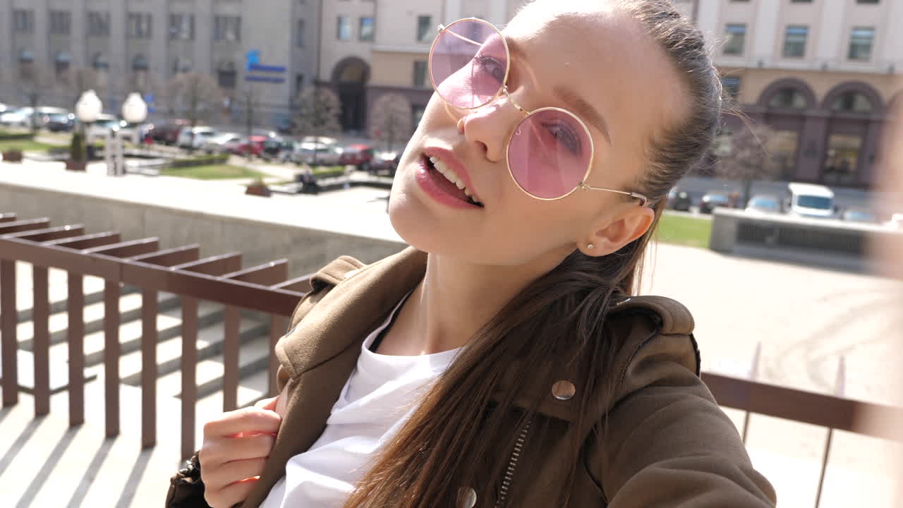 молодая женщина делает селфи в городе.