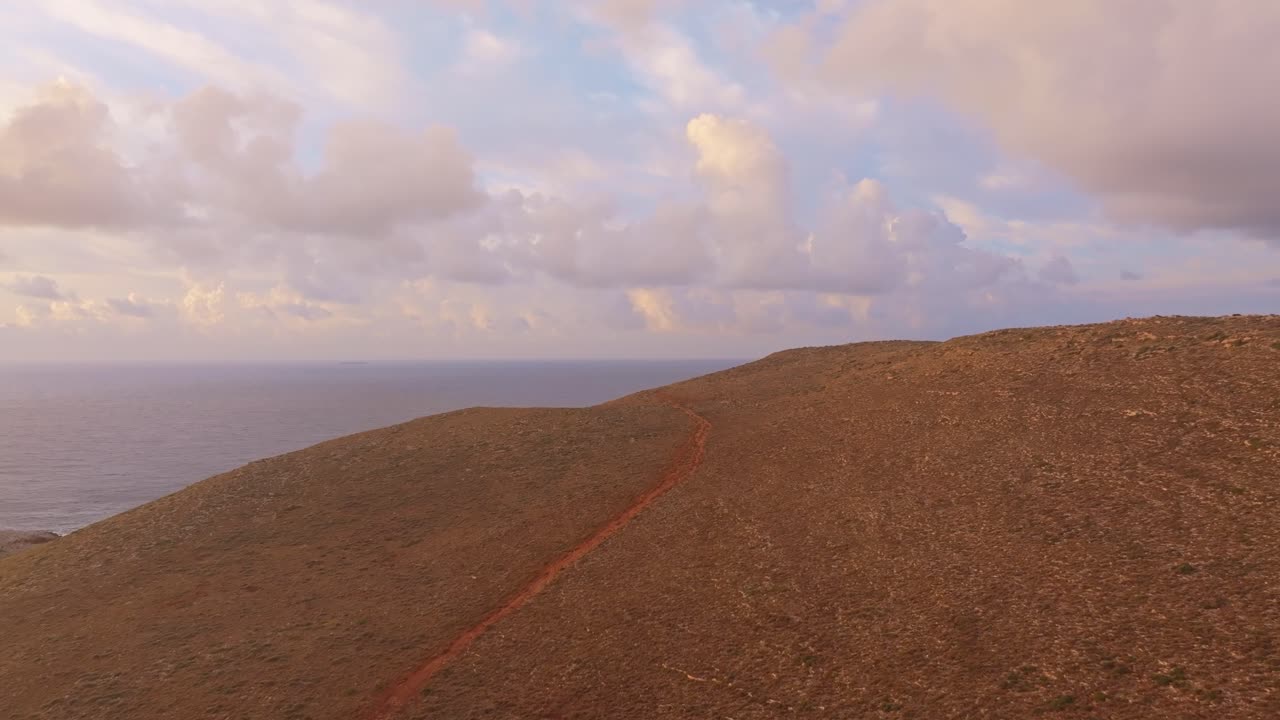 Vista aérea de colinas rochosas e mar agitado ao nascer do sol, Lagia, Grécia