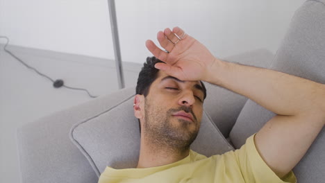 a good looking man is resting on a sofa