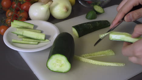 removing the seeds of green cucumber on the chopping board using a sharp knife - closeup shot