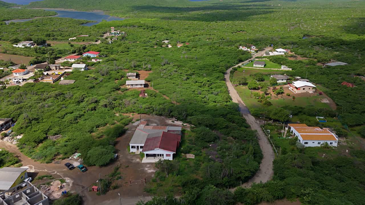 la sombra de las nubes pasa sobre las casas en el sinuoso camino tropical en el bosque bajo del caribe