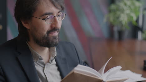man reading a book in a cafe