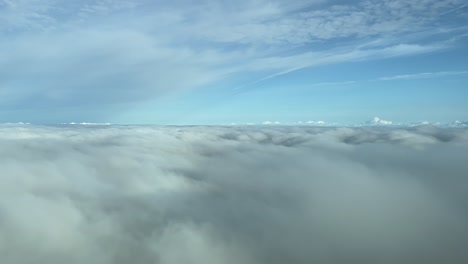 Overflying-a-blanket-of-clouds-during-cruise-level-phase-shot-from-an-airplane-cabin,-flying-at-12000m-high