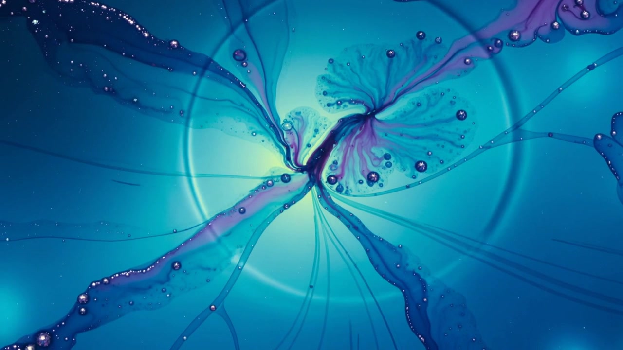 Rotation starting, core drawing blue tendrils inward in dish, droplets moving outward forming swirl