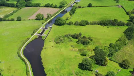 Aerial-view-over-an-English-canal-going-through-a-green-countryside-setting