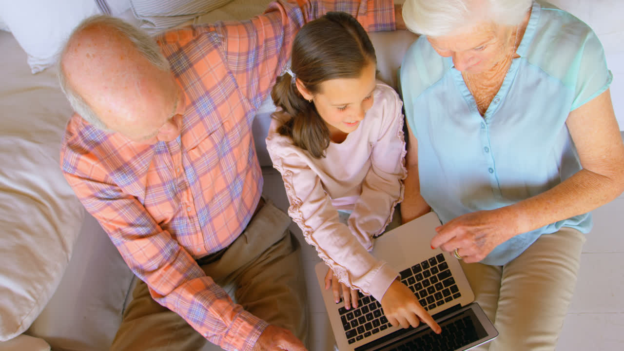 High angle view of Caucasian multi-generation family using laptop in a comfortable home 4k