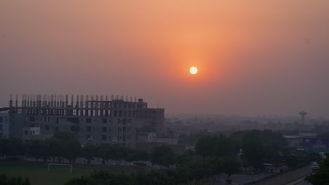 sunset behind the under-construction buildings in the fog in lahore pakistan