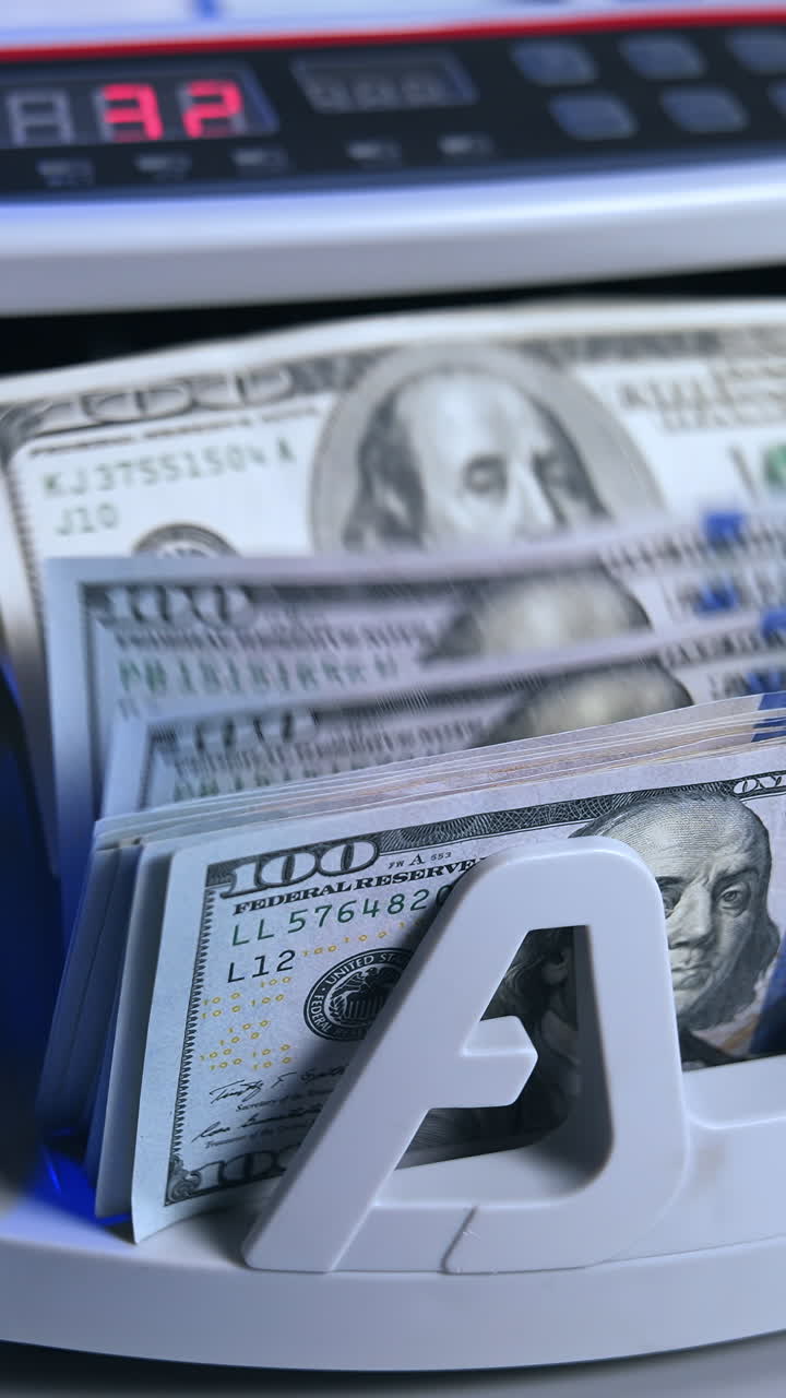 Bank cash counter machine with a stack of dollars. Horizontal view of the finance business money counting. Money and business concept. Vertical video