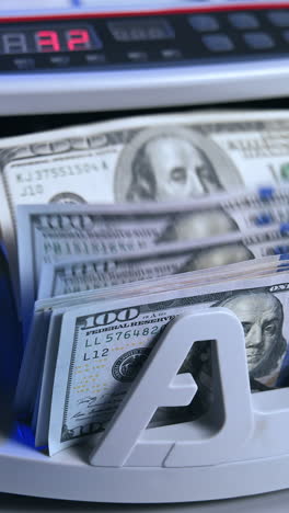 bank cash counter machine with a stack of dollars. horizontal view of the finance business money counting. money and business concept. vertical video