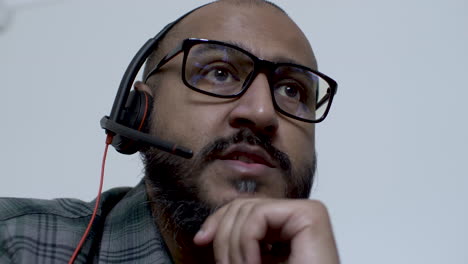 a close up shot of the face of an animated asian telemarketing salesman on a call with a potential customer, the man agreeing with the caller as he confidently talks into the microphone of his headset