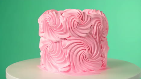 pink rosette cake on green background
