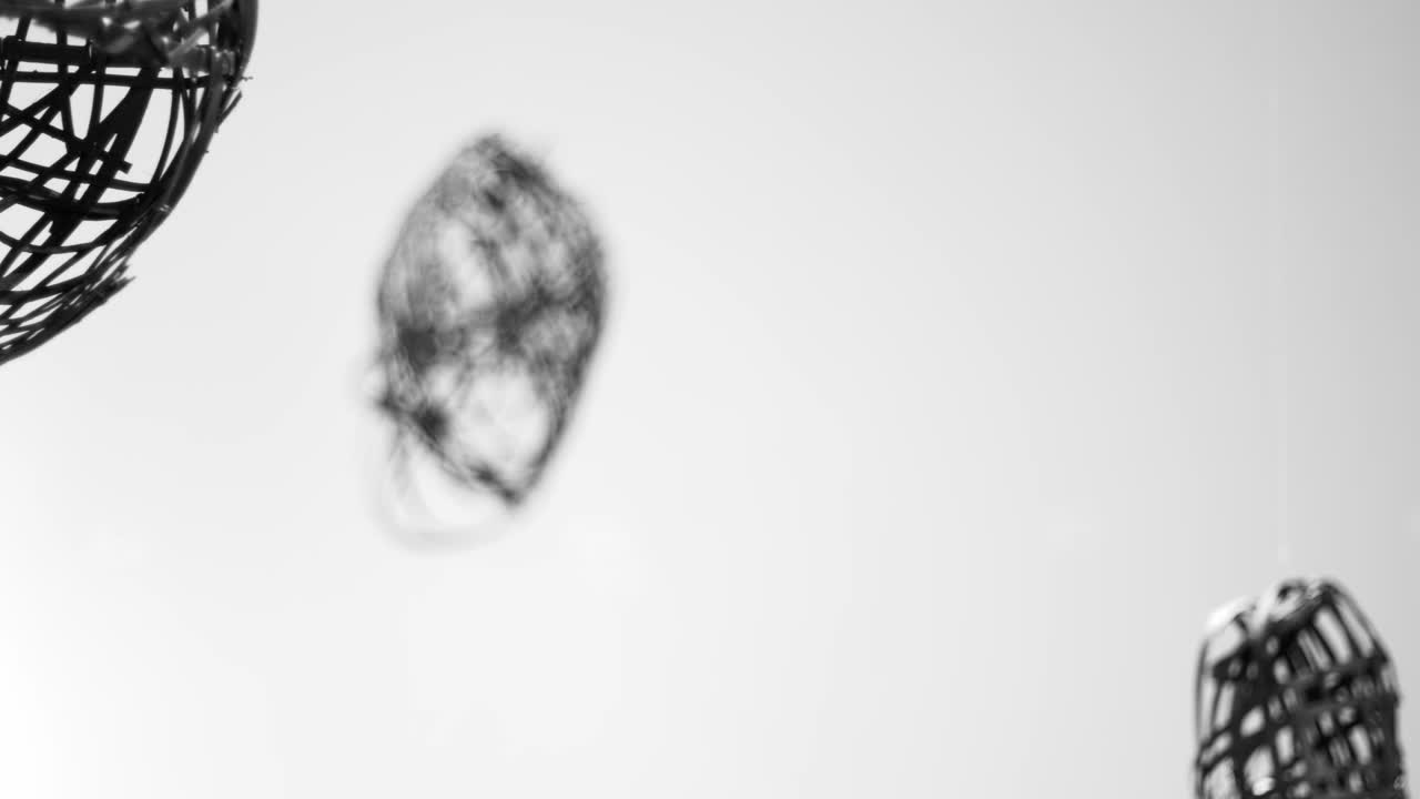 черные подвесные художественные скульптуры в белой комнате