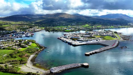 drone panorámica de la entrada a castletownbere puerto pesquero y ciudad, con las montañas de oeste corcho irlanda en el camino salvaje atlántico mañana de verano