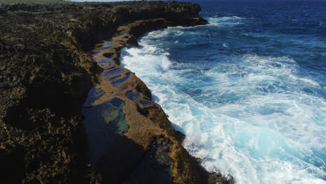 Lento-Ascenso-Aéreo-Sobre-Las-Piscinas-Oceánicas-Naturales-En-Cap-Des-Pins,-Nueva-Caledonia