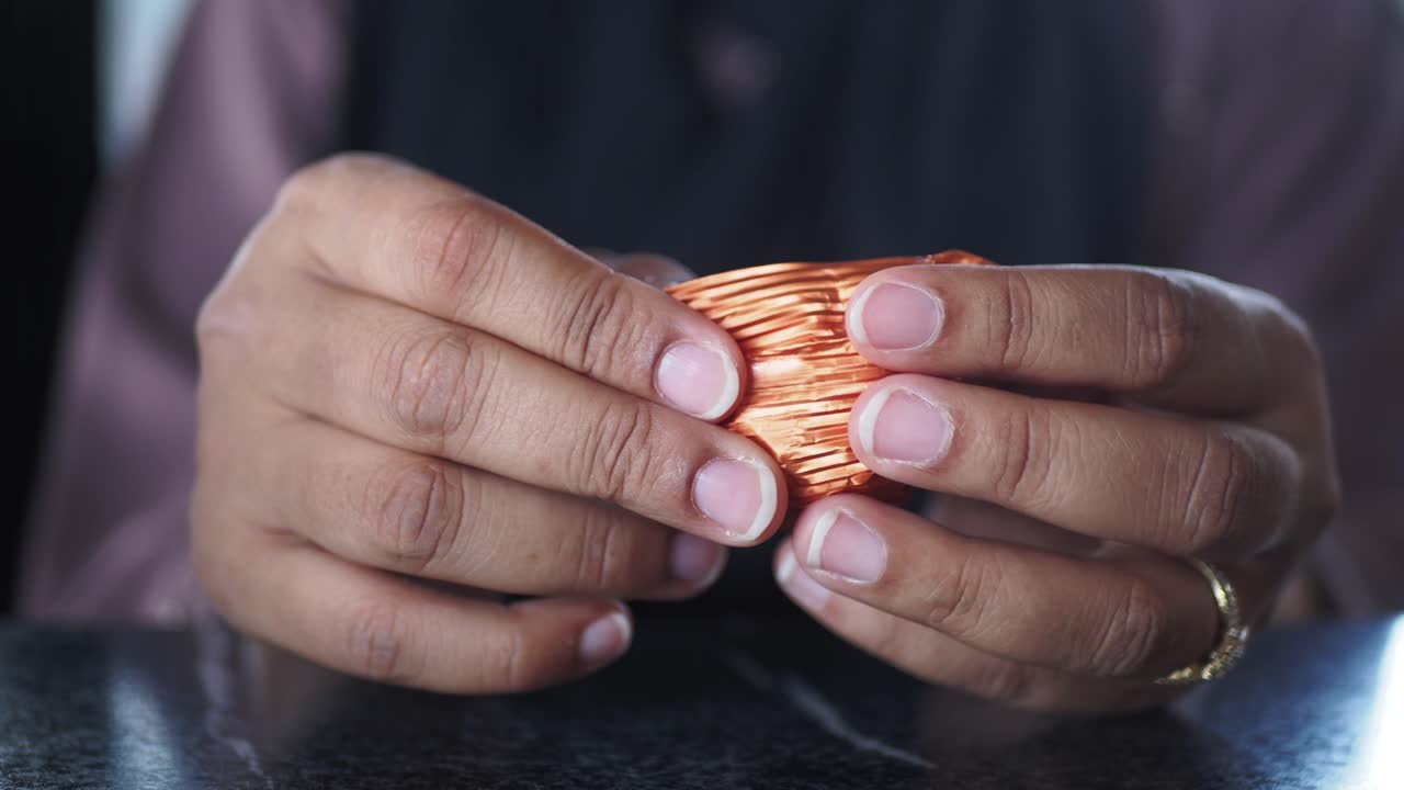 primer plano de las manos desempaquetando un caramelo de chocolate