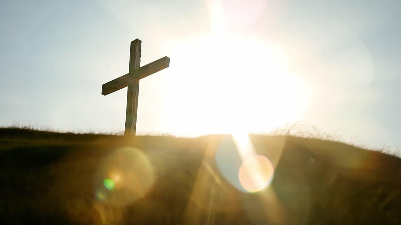 해가 뜨고 해가 지는 언덕 꼭대기에 있는 나무 십자가