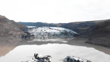 Kayaking-in-muddy-ice-moraine-lake-of-Solheimajokull-glacier,-Iceland