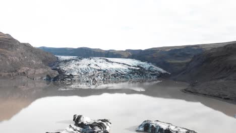 kayak en la morrena de hielo fangosa del lago del glaciar solheimajokull, islandia
