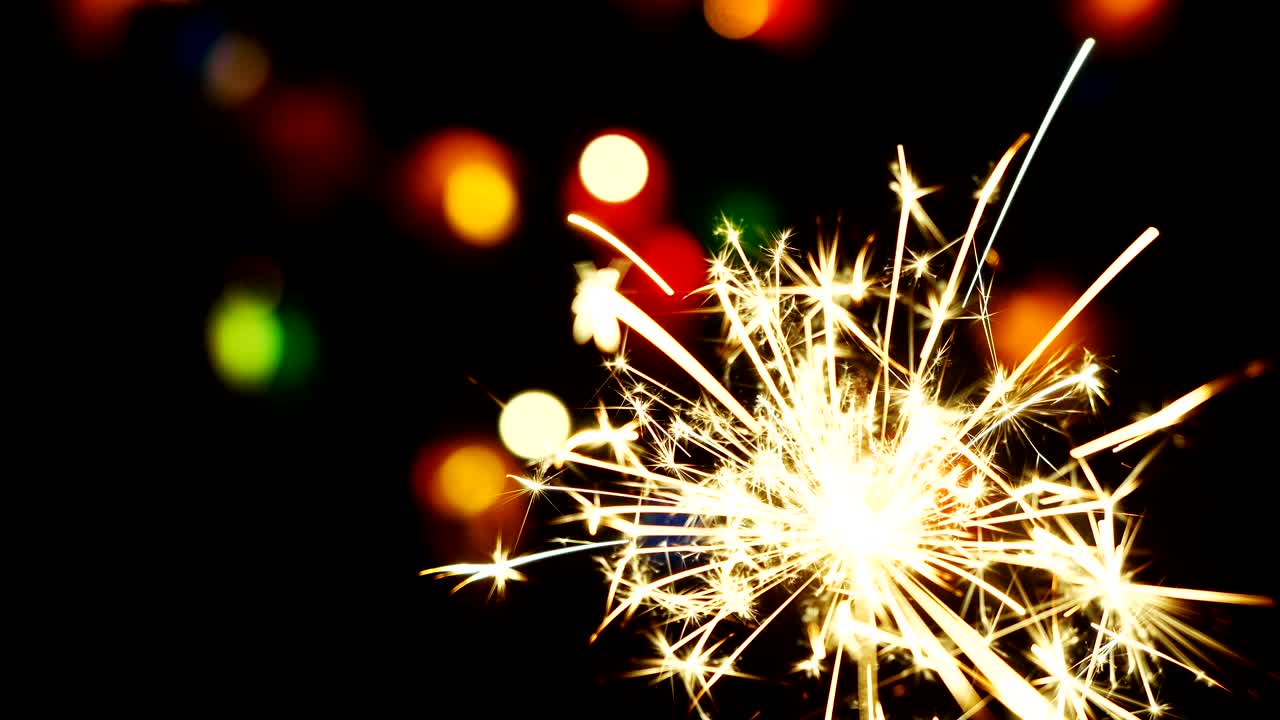 4k. Fireworks  and  blurred fires of garland on dark background