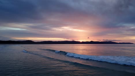 fly over sea waves during sunset on spirits bay near cape reinga in aupouri peninsula, north island, new zealand